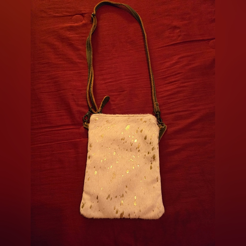 Very cute, small crossbody purse with cow hide and brown leather details.